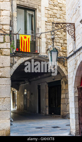 Flagge der Unabhängigkeitsbewegung von Katalonien, genannt Estelada (inoffiziell) in einer Straße der Innenstadt von Girona, Costa Brava, Spanien. Stockfoto