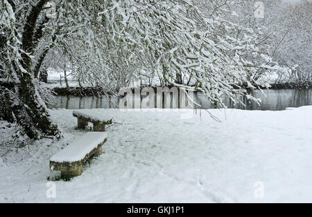 Einsamen Parkbank Schnee bedeckten, Stockfoto