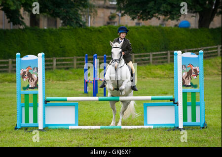 Junges Mädchen & ihr Pony springen Zäune in Golden Valley Ponyclub, Baskerville Hall, Clyro, Powys, Wales, UK Stockfoto