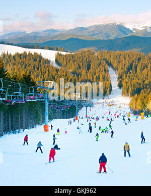 Menschen, Skifahren und Snowboarden am Hang im Skigebiet Stockfoto