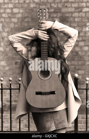 Country-Musik star Performer weiblich, geschossen von hinten, Ziegel-Wand-Hintergrund Stockfoto