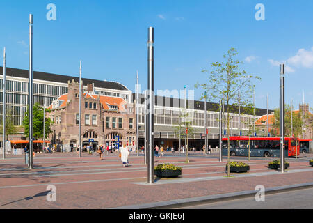 Bahnhofsgebäude, Busse und Passanten am Stationsplein Square im Stadtzentrum von Haarlem, Holland, Niederlande Stockfoto