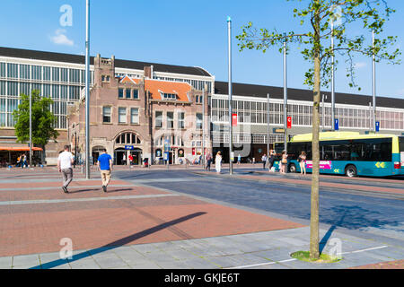 Menschen, Bus und Bahnhofsgebäude am Stationsplein Square im Stadtzentrum von Haarlem, Holland, Niederlande Stockfoto