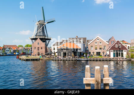 Waterfront Café mit Menschen, Windmühle, Adriaan und Spaarne Fluss in Haarlem, Holland, Niederlande Stockfoto