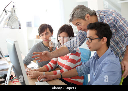 Lehrer mit Schülern arbeiten auf desktop Stockfoto