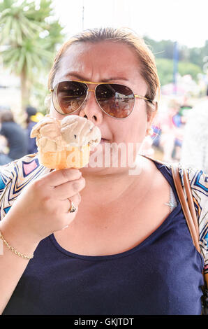 Eine Frau mit Sonnenbrille genießt ein Eis zu essen. Stockfoto