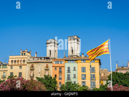 Flagge von Katalonien, genannt Senyera, winken in der Innenstadt von Girona mit Glockentürmen Anunciación Klosters. Girona, Spanien. Stockfoto