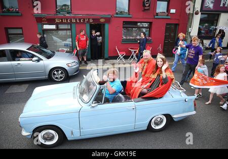 Der neu gekrönte König und Königin der rothaarige Alan O'Neill und Emma Ni Chearuil mit ihren Fahrer Denis Cronin führen die Parade auf der irischen Rothaarige Convention im Dorf Crosshaven in Cork, Irland statt. Stockfoto