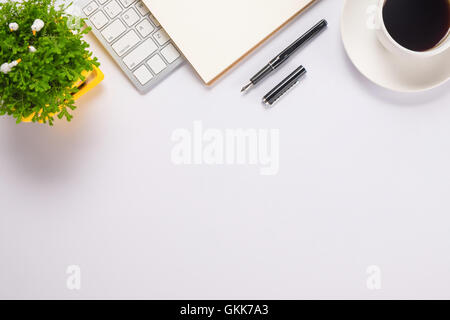Büro Schreibtisch Tisch Computer, Zubehör, Papier, Stift, Tasse Kaffee und Blume Draufsicht mit Textfreiraum Stockfoto