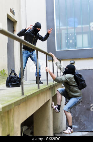 Flucht aus einem Raubüberfall. Man versucht zu helfen, die Schienen zu klettern. Stockfoto