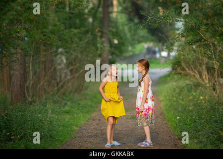 Zwei kleine Freundinnen emotionale reden stehen in einem Park. Stockfoto