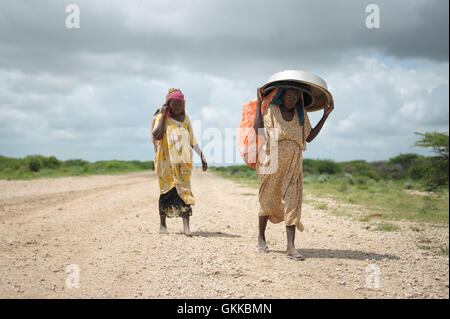 Frauen gehen mit welchen Besitzschutz, die sie tragen können, kommen in ein stetiges Rinnsal in einem Flüchtlingslager errichtet neben einer AMISOM Militärbasis in der Nähe der Stadt Jowhar, Somalia, am 12. November. Heftige Regenfälle in Somalia, gepaart mit den letzten Auseinandersetzungen zwischen Clans, führte über viertausend Vertriebene Zuflucht auf einer AMISOM Militärbasis in der Nähe der Stadt Jowhar mit mehr Anreise täglich. AU UN IST Foto / Tobin Jones Stockfoto