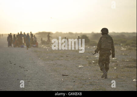 Eine Afrikanische Union Soldat, Zugehörigkeit zu den ugandischen Kontingent von AMISOM, geht eine Straße neben einem Flüchtlingslager in der Nähe der Stadt Jowhar, Somalia, am 14. Dezember. Kämpfe zwischen den Clans hat mehr als zwölftausend Menschen in der Nähe der Stadt Jowhar, Somalia vertrieben. Viele haben versucht, Notunterkünfte in der Nähe einer afrikanischen Union Militärlager in der Gegend, wer derzeit die Sicherheit für die Binnenvertriebenen zur Verfügung stellen. AU UN IST Foto / Tobin Jones. Stockfoto