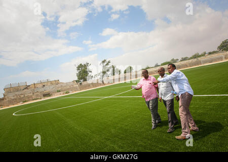 SOMALIA, Mogadischu: Ein Handout Foto vom 12 Januar und freigegeben von der hybride Nationen Informationen Support Team 16 Januar zeigt Mitglieder des somalischen Football Federation (FSF) zu Fuß auf dem Fußballplatz im Baanadir-Stadion im Stadtteil Abd-Aziz von der somalischen Hauptstadt Mogadischu, die vor kurzem mit einer neuen künstlichen Spielfläche wurden wieder aufgetaucht. Finanziert von der FIFA, die FSF hat die 7.500-fassende Stadion neu begrünt und wird in Kürze beginnen Reparaturarbeiten an Plätze, Parkplätze und andere Einrichtungen, die derzeit mit Erinnerungen an Somalia Krieg heimgesuchten Vergangenheit gespickt sind. Achtern Stockfoto