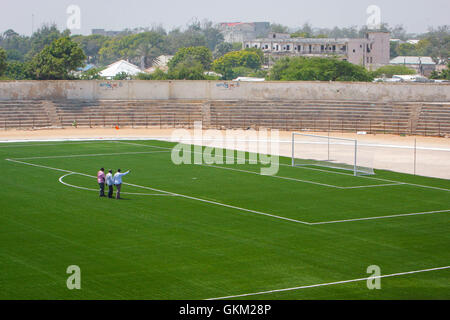 SOMALIA, Mogadischu: Ein Handout Foto vom 12 Januar und veröffentlicht von der hybride Nationen Informationen Support Team 16 Januar, pitch zeigt Mitglieder des somalischen Football Federation (SFF) zu Fuß über den Fußball im Baanadir-Stadion im Stadtteil Abd-Aziz von der somalischen Hauptstadt Mogadischu, die vor kurzem mit einer neuen künstlichen Spielfläche wurden wieder aufgetaucht. Finanziert von der FIFA, die FSF hat die 7.500-fassende Stadion neu begrünt und wird in Kürze beginnen Reparaturarbeiten an Plätze, Parkplätze und andere Einrichtungen, die derzeit mit Erinnerungen an Somalia Krieg heimgesuchten Vergangenheit gespickt sind. Stockfoto