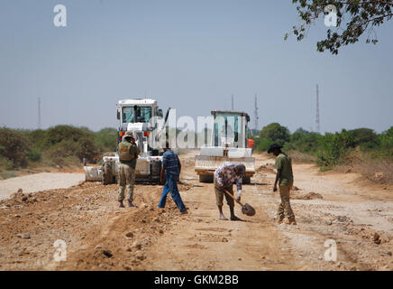 SOMALIA, Mogadischu: In einem Photgraph 24 Januar aufgenommen und veröffentlicht von der hybride Nationen Informationen Support Team 26 Januar, Mission der Afrikanischen Union in Somalia (AMISOM) Ingenieure und Somali Arbeiter Grade zu bekämpfen und Reparatur ein Stück der Straße nach der Stadt Afgooye in Somalia im unteren Shabelle Region entlang der Hauptroute, die Verknüpfung der fruchtbaren, landwirtschaftliche Region mit der Hauptstadt Mogadischu. Nach Jahren von der gewalttätigen Al-Qaida verbundenen Extremistengruppe Al Shabaab kontrollierten waren erstreckt sich von der wirtschaftlich wichtige Durchgangsstraße praktisch in befahrbar. Jetzt, 7 Monate nach th Stockfoto