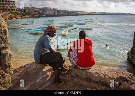 SOMALIA, Mogadischu: In einem Foto 16. März 2013 und Freigabe durch die hybride Nationen Informationen Support Team 18 März blicken zwei somalische Männer über Mogadischus Fischerhafen in den frühen Morgenstunden wie Fischer ihren Fang zu landen und ihre Fische auf dem Markt im Stadtteil Xamar Weyne der somalischen Hauptstadt transportieren. Jeden Morgen bringen Mogadischus Fischer ihren Fang aus dem indischen Ozean an Land, auf denen es schnell entladen und Transport ist Xamar Weyne es lebhaft und chaotisch Fish Market wo es verkauft wird für den Verzehr auf dem lokalen Markt und in zunehmendem Maße für expor Stockfoto