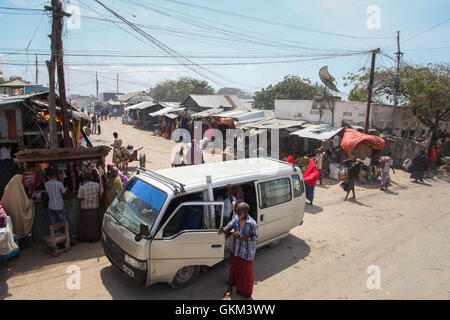 SOMALIA, Kismayo: Auf einem Foto genommen 15. Juli 2013 und die hybride Nationen Informationen Support Team 22 Juli veröffentlicht, niederlässt ein Mann aus einem Taxi Pendler als eine Mission der Afrikanischen Union in Somalia (AMISOM) Konvoi Pässe Throught Zentrum von Kismaayo im Süden Somalias. AU-UN IST FOTO / RAMADAN MOHAMED HASSAN. Stockfoto