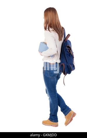 Mädchen mit einem Rucksack auf dem Rücken ist ein Stapel von Büchern. hinten Sie Ansicht von. Hintere Ansicht Menschen Sammlung. Rückseite Blick auf Person. Isoliert auf weißem Hintergrund. Stockfoto