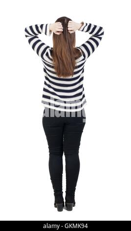 Rückansicht des schockiert Frau in Jeans. Mädchen versteckte seine Augen hinter seinen Händen. Hintere Ansicht Menschen Sammlung. Rückseite Blick auf Person. Isoliert auf weißem Hintergrund. Das Mädchen in den gestreiften Pullover ist sein Kopf umklammert. Stockfoto