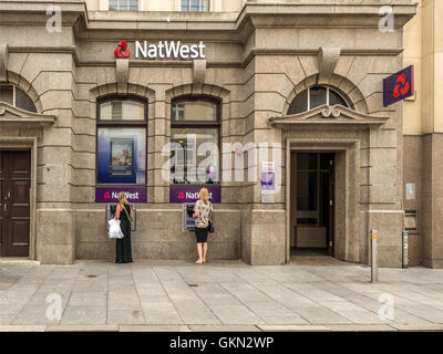 Natwest Bank, Exeter City Centre, Devon, zwei Weibchen aus Geldautomaten Bargeld ziehen. Stockfoto