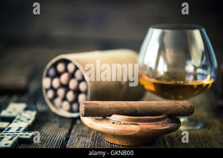 kubanische Zigarre und ein Glas Rum oder Cognac auf Holztisch Stockfoto