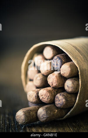 Reihe von Zigarren gewickelt in Palmblatt auf Holztisch, launisch und dunklen Bild Stockfoto