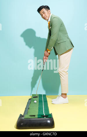 Junger Mann beim Golfen Stockfoto