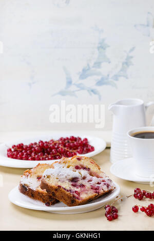 Frühstück-Thema. Zwei Stück hausgemachten Kuchen mit roten Johannisbeeren, serviert auf weißen Teller mit Puderzucker, frische Beeren, Tasse co Stockfoto