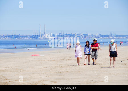 4 Freunde zu Fuß am Strand von Trouville-sur-Mer in der Normandie, mit Le Havre im Hintergrund Stockfoto