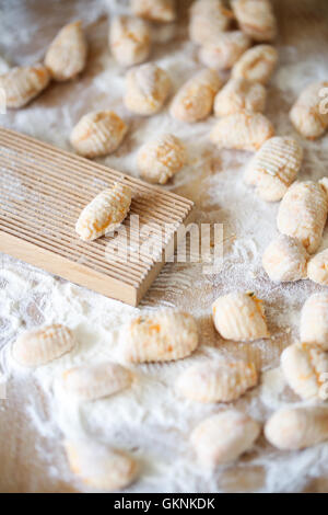 Hausgemachte Kürbis Gnocchi auf einem Nudelbrett mit einem typischen Kamm für pasta Stockfoto