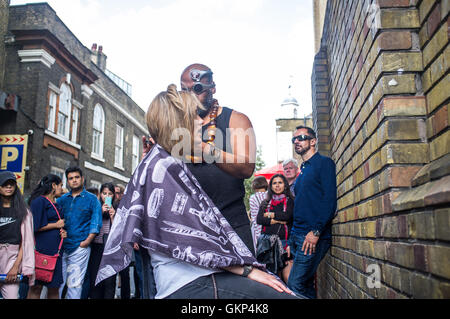 London, UK. 21. August 2016. Eine Straße Friseur führt in Brick Lane tanzen zur Musik beim Haare schneiden. Bildnachweis: Alberto Pezzali/Alamy Live-Nachrichten Stockfoto