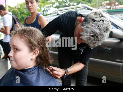 Alajuela, Costa Rica. 21. August 2016. Acht-jährige Lucia Chavez Reyes, spendet ihr Plaid um Perücken für Krebspatienten während einer philanthropischen Veranstaltung von der Ana Ross Foundation in Alajauela, Costa Rica, am 21. August 2016 machen. Familienmitglieder gründete die Stiftung Ana Ross, ein Costa Rica Arzt zu gedenken, die im Jahr 2003 an Krebs gestorben. Ana Ross plädiert für Unternehmen und Hilfe für Krebs-Patienten und sich selbst. © Kent Gilbert/Xinhua/Alamy Live-Nachrichten Stockfoto