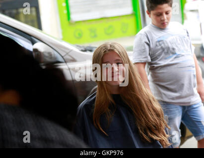 Alajuela, Costa Rica. 21. August 2016. Acht-jährige Lucia Chavez Reyes, spendet ihr Plaid um Perücken für Krebspatienten während einer philanthropischen Veranstaltung von der Ana Ross Foundation in Alajauela, Costa Rica, am 21. August 2016 machen. Familienmitglieder gründete die Stiftung Ana Ross, ein Costa Rica Arzt zu gedenken, die im Jahr 2003 an Krebs gestorben. Ana Ross plädiert für Unternehmen und Hilfe für Krebs-Patienten und sich selbst. © Kent Gilbert/Xinhua/Alamy Live-Nachrichten Stockfoto