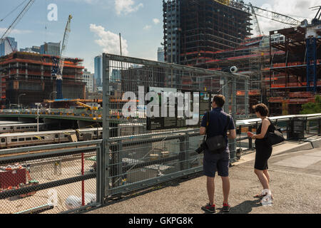 Touristen zu lesen ein Schild mit Informationen über die High Line-Verlängerung in der Nähe von Hudson Yards Entwicklung in New York City. Stockfoto