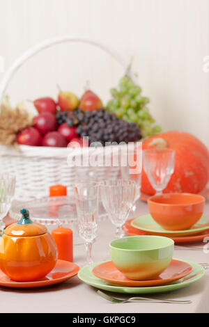 Thanksgiving Day. Festliches Mittagessen mit traditionellen Tischdekoration - Kürbisse, Früchte und Gemüse. Tabelle Einstellung in Orange und Stockfoto