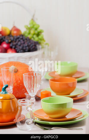 Thanksgiving Day. Festliches Mittagessen mit traditionellen Tischdekoration - Kürbisse, Früchte und Gemüse. Tabelle Einstellung in Orange und Stockfoto