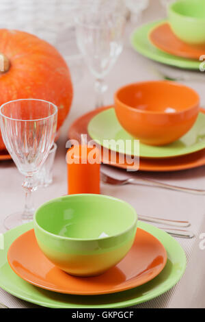 Thanksgiving Day. Festliches Mittagessen mit traditionellen Tischdekoration - Kürbisse, Früchte und Gemüse. Tabelle Einstellung in Orange und Stockfoto