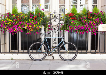 Fahrrad angekettet an ein Geländer vor ein schönes Haus Stockfoto