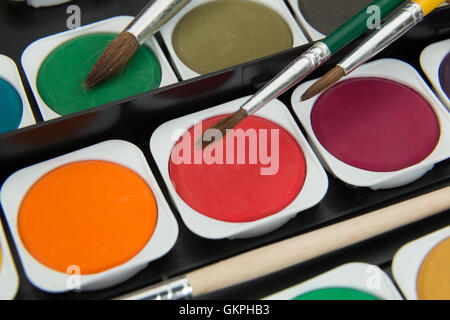 neue unbenutzte Palette von mehrfarbigen Aquarellfarben mit Pinsel Stockfoto