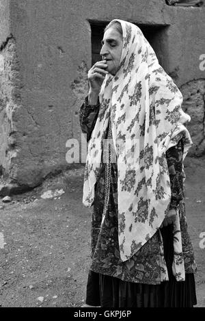 Soghra ist eine Abyanaki Frau, deren Familie all das Dorf verlassen hat. Abyāneh ist ein Dorf im Barzrud des Rural District, im zentralen Bezirk von Natanz County, Provinz Isfahan, Iran. Bei der Volkszählung 2006 war die Bevölkerung 305, in 160 Familien. Zeichnet sich durch eine eigenartige rötlichen Farbton, das Dorf ist eines der ältesten im Iran. Eine Abyanaki Frau trägt in der Regel einen weißen langen Schal (für die Schultern und oberen Stamm) hat eine bunte Muster und eine unzureichende Knie Rock. Stockfoto
