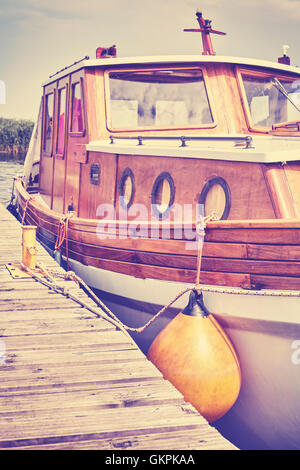 Retro-stilisierte Holzboot auf einer Mole im Hafen festgemacht. Stockfoto