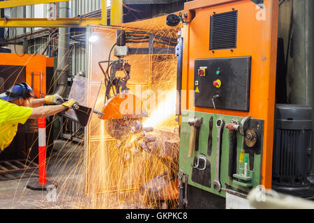 Arbeiter, Schleifen oder Schneiden entfernt werfen Metallkomponenten aus seinem "Casting" Baum. Stockfoto