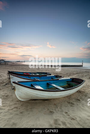 Eine Reihe von Booten bei Sonnenaufgang am Strand von Bournemouth in Dorset Stockfoto