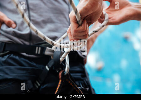 Nahaufnahme der Kletterer Sicherheitsgurt anlegen und Kletterausrüstung im freien Stockfoto