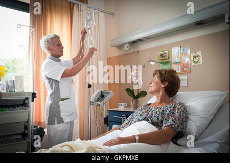 Verpleegkundigen Sluiten Een Infuus Aan Bij de Patienten. Verpleegkundige Bereid de Infuuszak Voor de de Andere Verpleegkundige pa Stockfoto