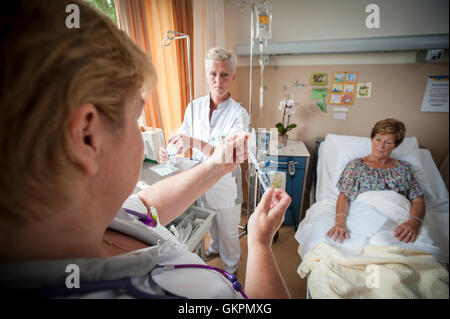 Verpleegkundigen Sluiten Een Infuus Aan Bij de Patienten. Krankenschwestern, die Vorbereitung einer iv für den Patienten. Stockfoto