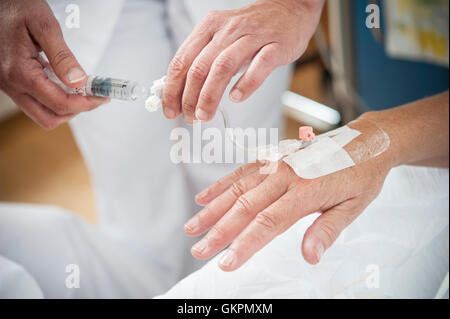 Verpleegkundigen Sluiten Een Infuus Aan Bij de Patienten. De Verpleegkundige Plakken de Infuusnaald af de Sluite Het Infuus Aan. Stockfoto