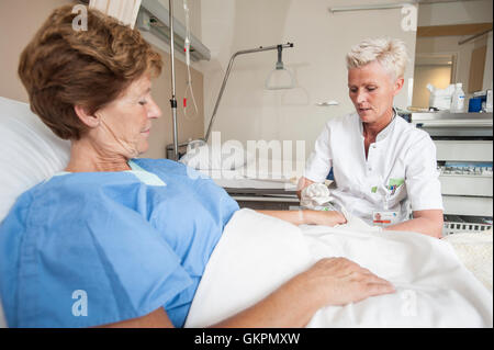 Verpleegkundigen Sluiten Een Infuus Aan Bij de Patienten. Krankenschwestern, die Vorbereitung einer iv für den Patienten. Stockfoto