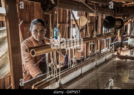 Arbeitnehmerin webt Stoff in einer Weberei Fabrik am Inle-See. Stockfoto